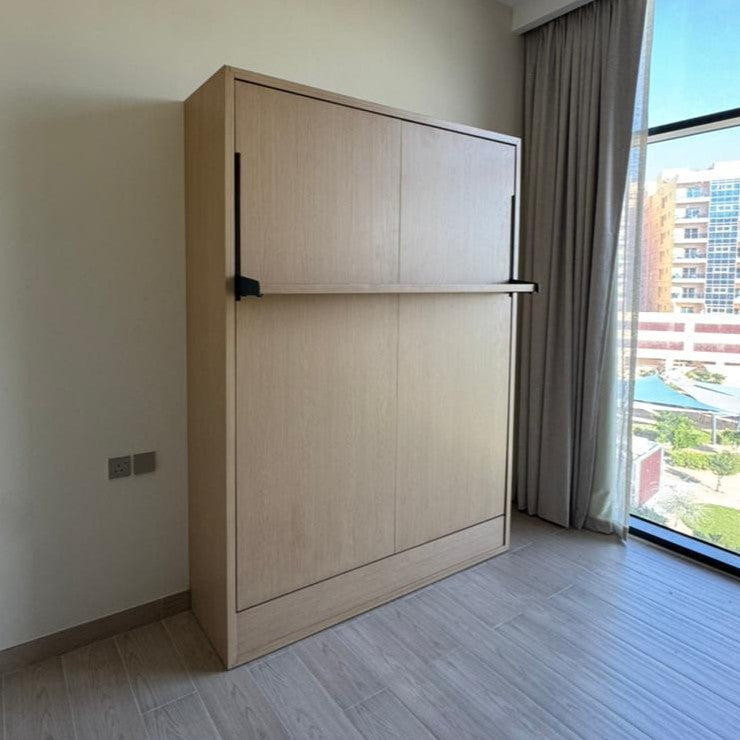Wooden Murphy bed in a room with a window and curtains.