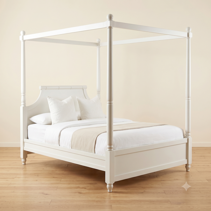 White four-poster bed with white bedding in a room with beige walls and wooden flooring.